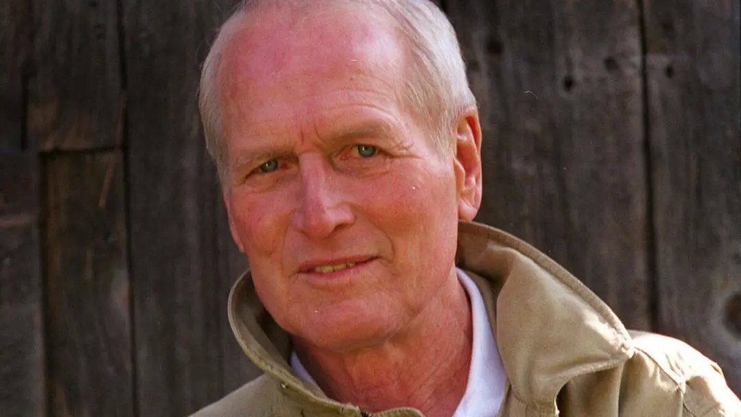 چهره پل نیومن (Paul Newman) در مقابل یک پس‌زمینه چوبی