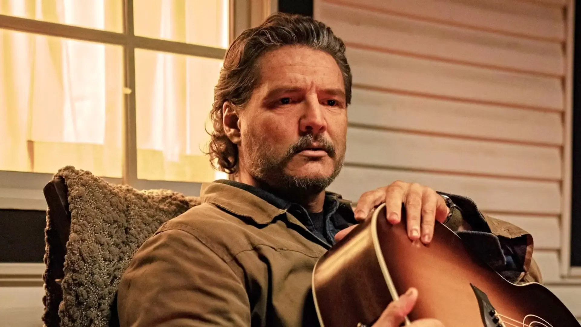 پدرو پاسکال (Pedro Pascal) در حالی که یک گیتار را در آغوش گرفته است