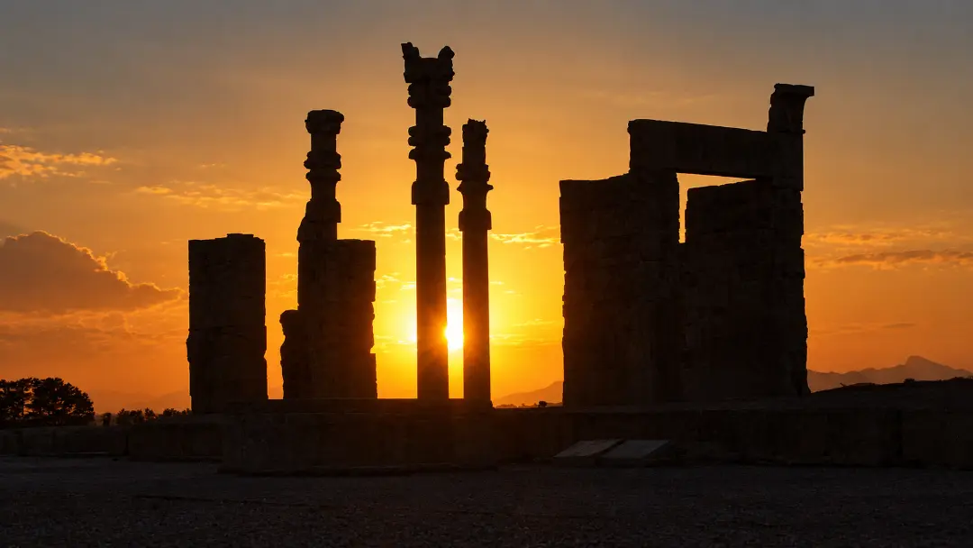 ستون‌های سنگی تخت جمشید (Persepolis) در برابر نور خورشید هنگام غروب