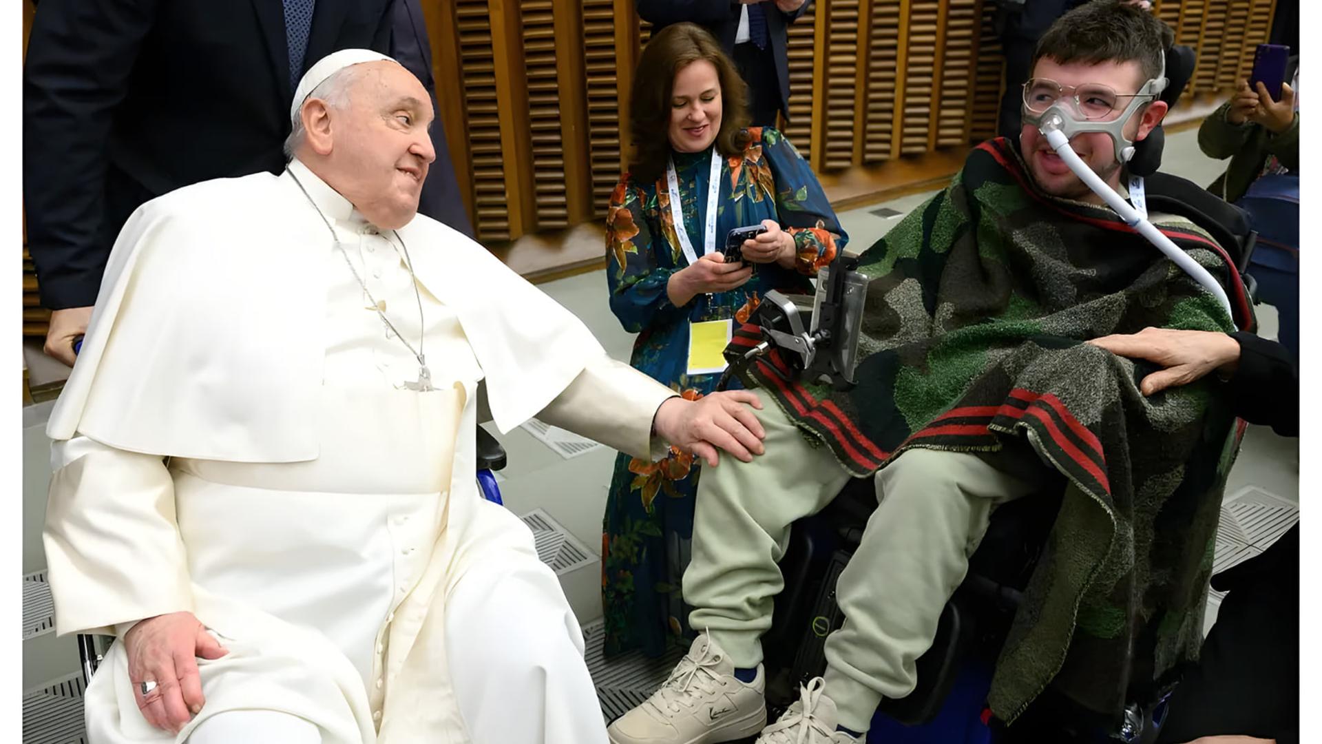 پاپ فرانسیس (Pope Francis) در حال دست دادن با مردی که روی ویلچر نشسته است