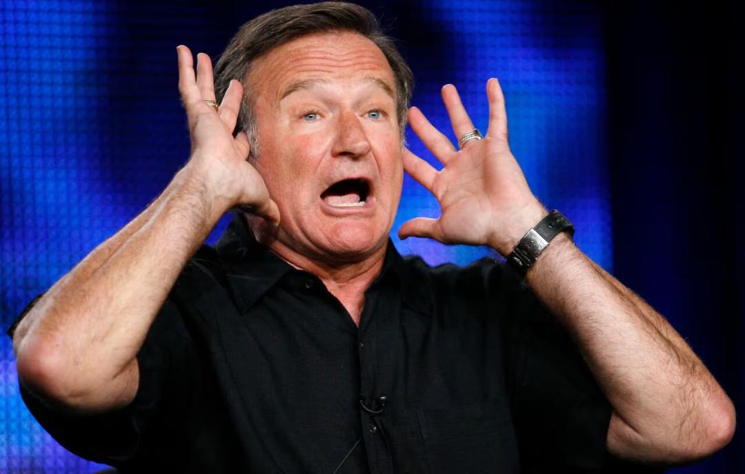 رابین ویلیامز (Robin Williams) با دست‌های باز در حال اجرای کمدی
