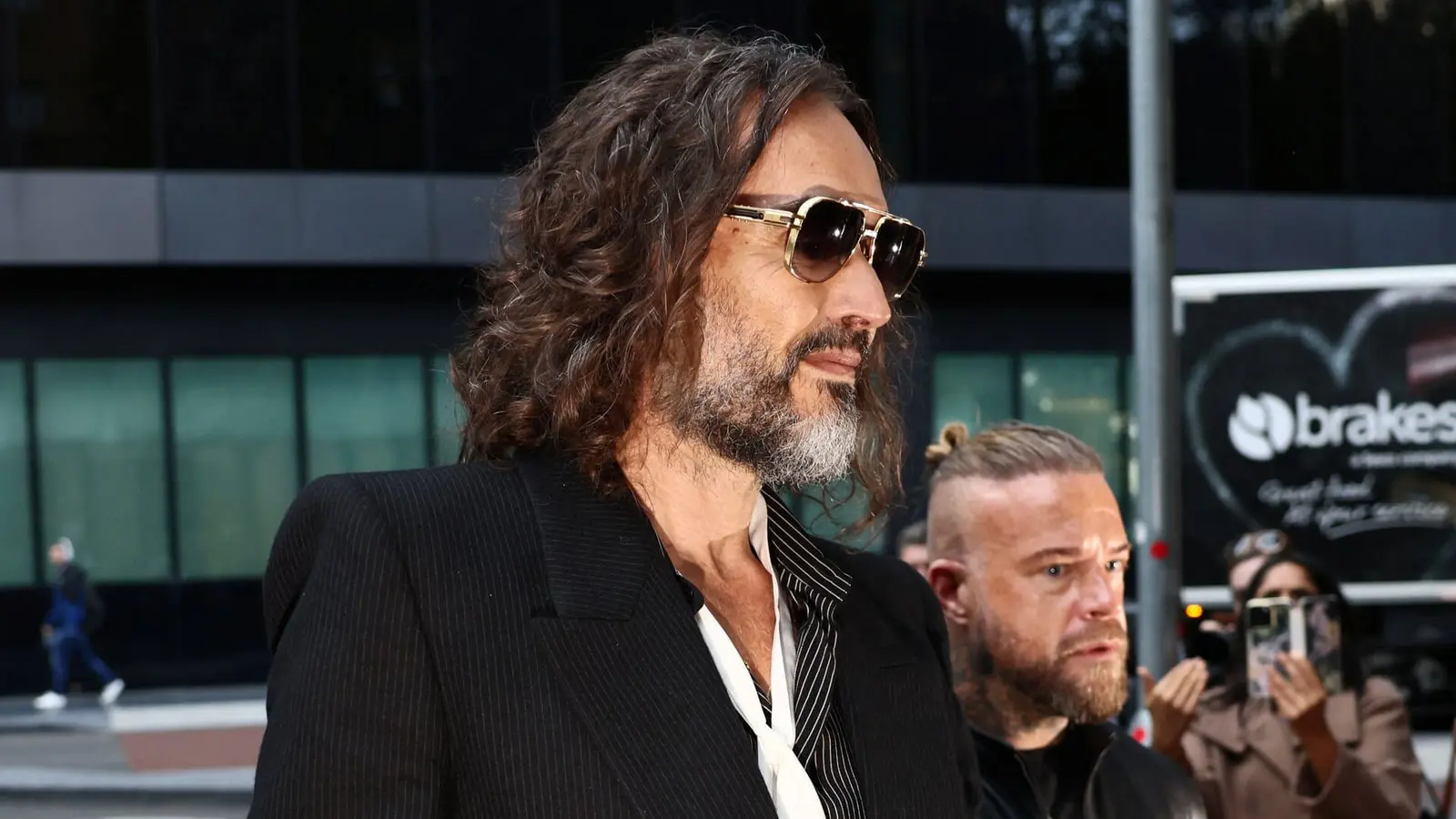 راسل برند (Russell Brand) با عینک آفتابی در محیطی شهری