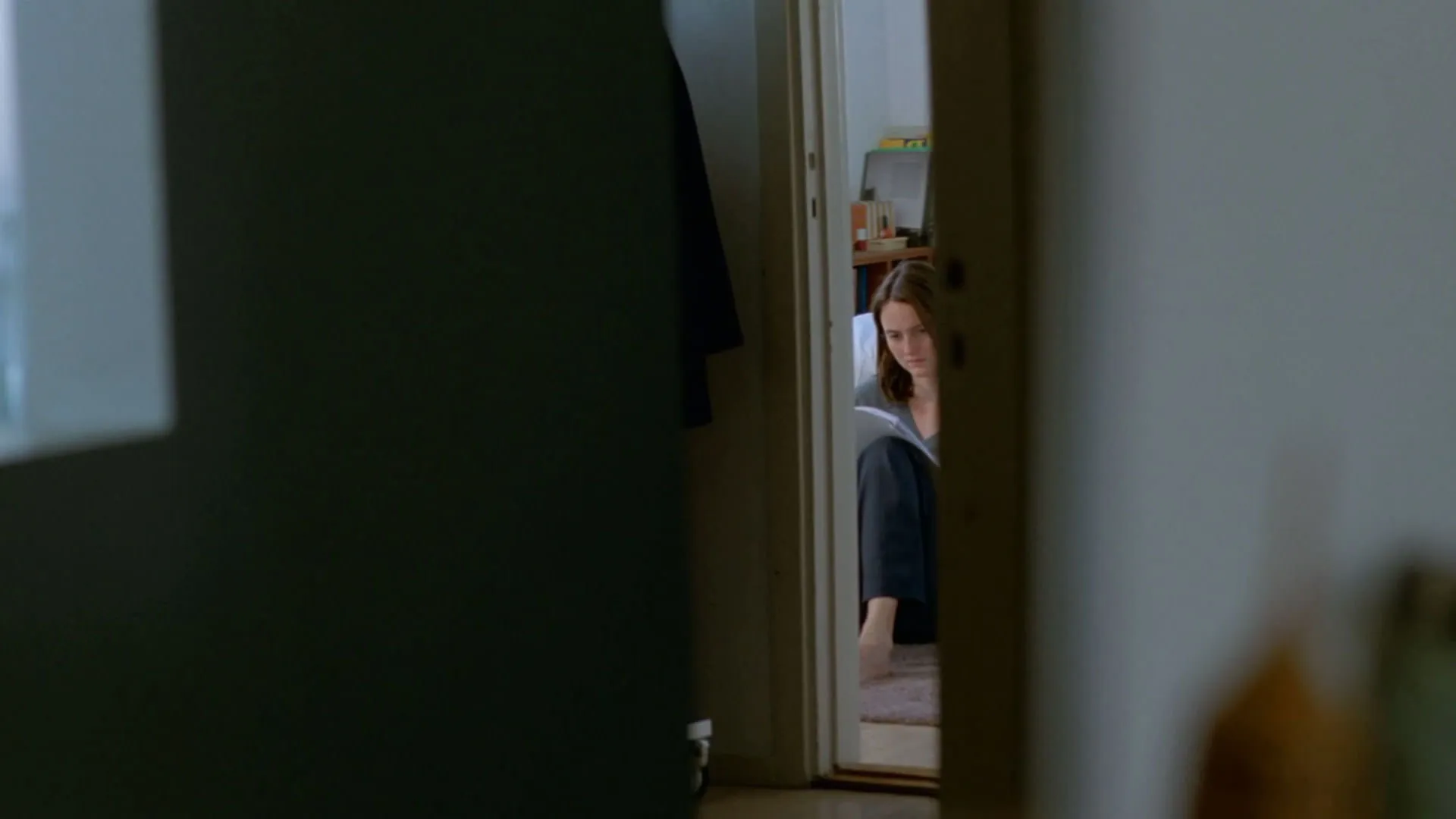 رناته رینسوه را از لای در اتاق می‌بینیم که چیزی می‌خواند در فیلم ارزش عاطفی یواکیم تریه