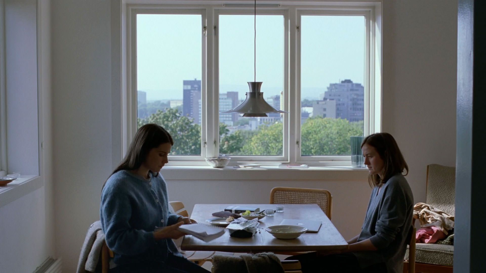 رناته رینسوه پشت یک میز مقابل اینگا ایبسدوتر لیلیاس نشسته است در فیلم ارزش عاطفی یواکیم تریه