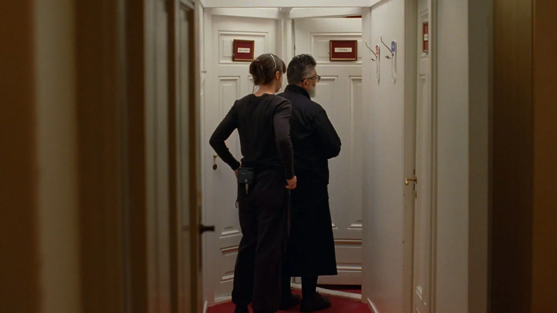 یک مرد و یک زن داخل راهرویی تنگ میان دو در ایستاده‌اند در فیلم ارزش عاطفی یواکیم تریه