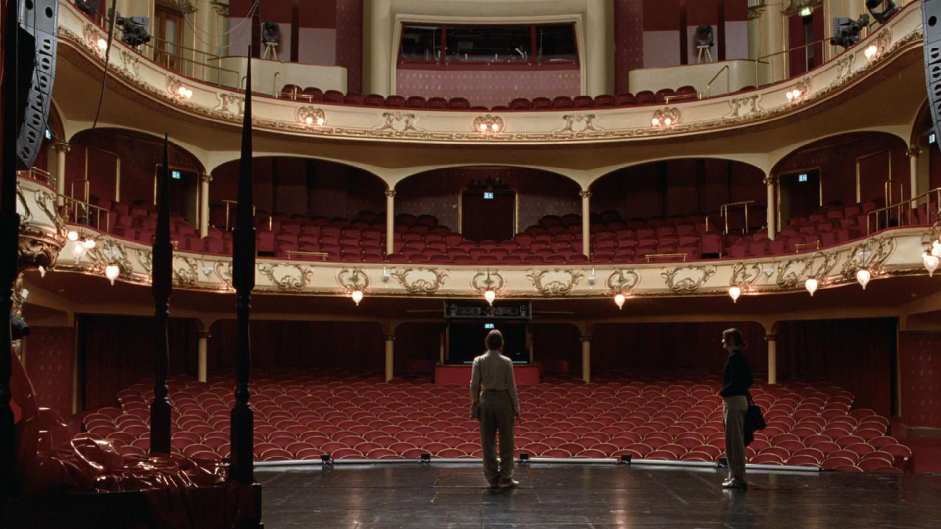 سالن بزرگ تئاتر با صندلی‌هایی سرخ در فیلم ارزش عاطفی یواکیم تریه