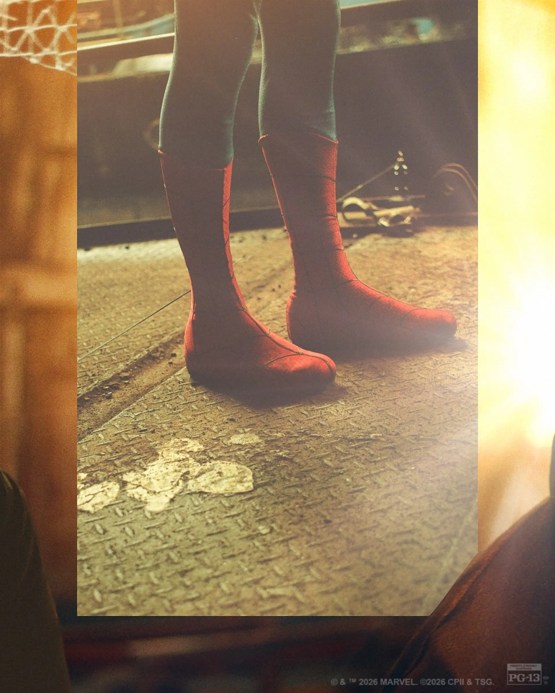 پایهای مرد عنکبوتی (Spider-Man) با لباس قرمز و آبی روی سطح فلزی