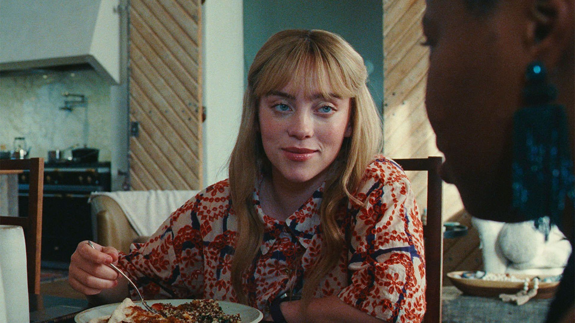 بیلی آیلیش در حال غذا خوردن در نمایی از سریال توده آمازون