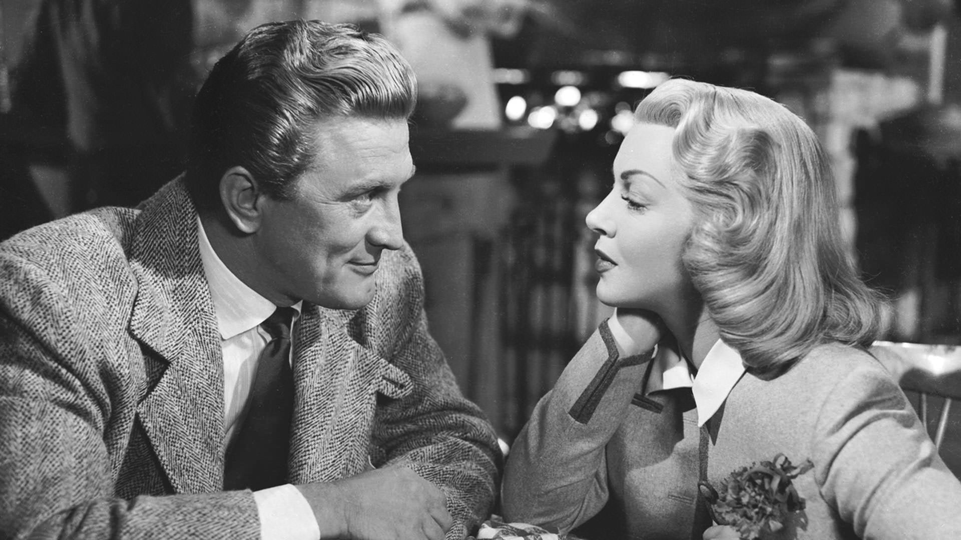 کرک داگلاس نشسته مقابل لانا ترنر در نمایی سیاه و سفید از فیلم بد و زیبا وینست مینلی