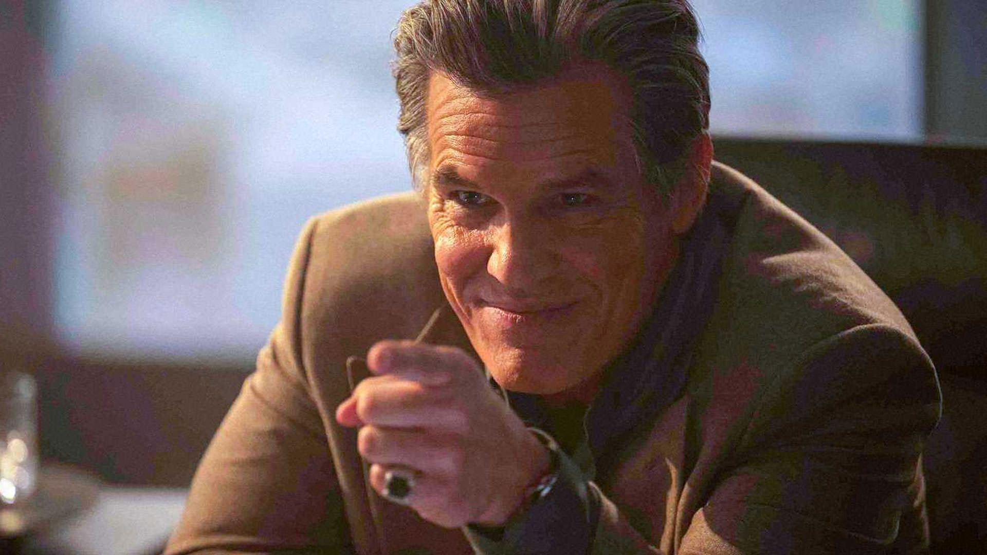 جاش برولین با لبخند به رو به رو اشاره می‌کند در نمایی از فیلم مرد فراری ادگار رایت