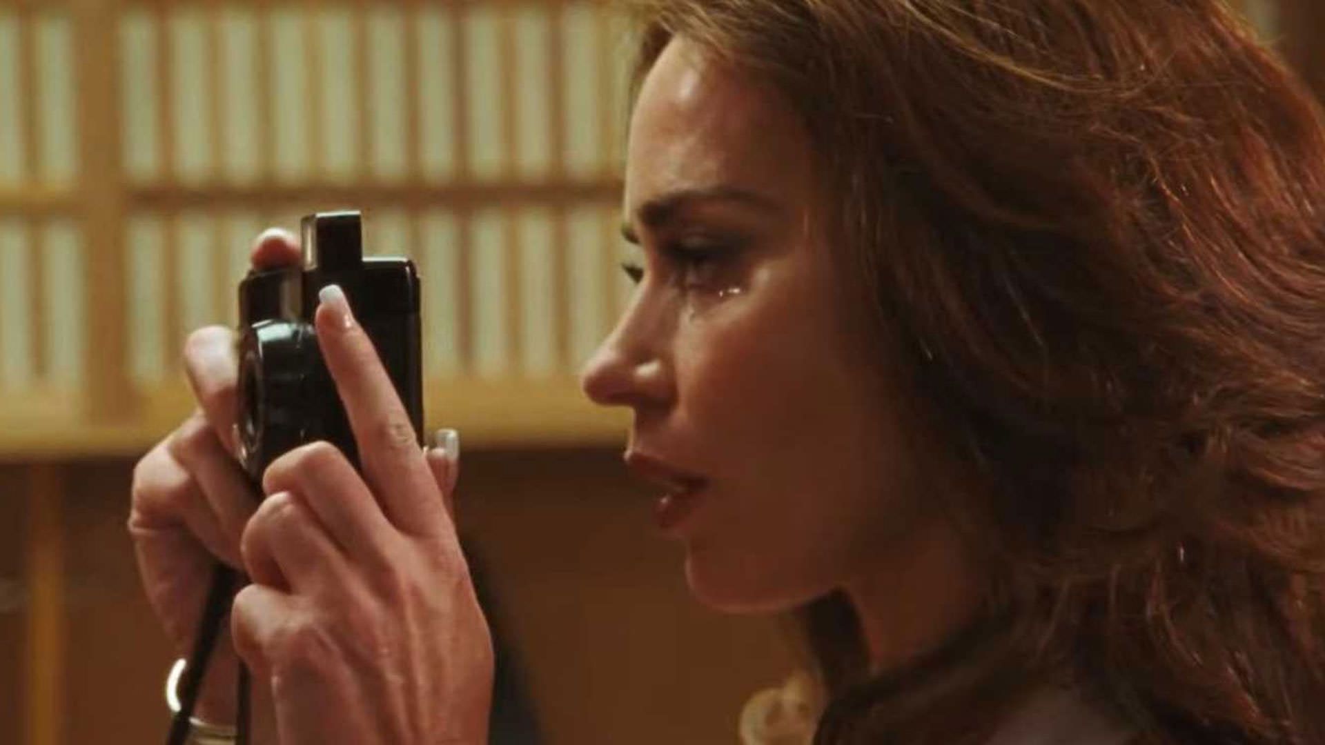 امیلی بلانت گریان در حال عکس گرفتن با دوربین در نمایی از فیلم ماشین کوبنده به کارگردانی بنی سفدی