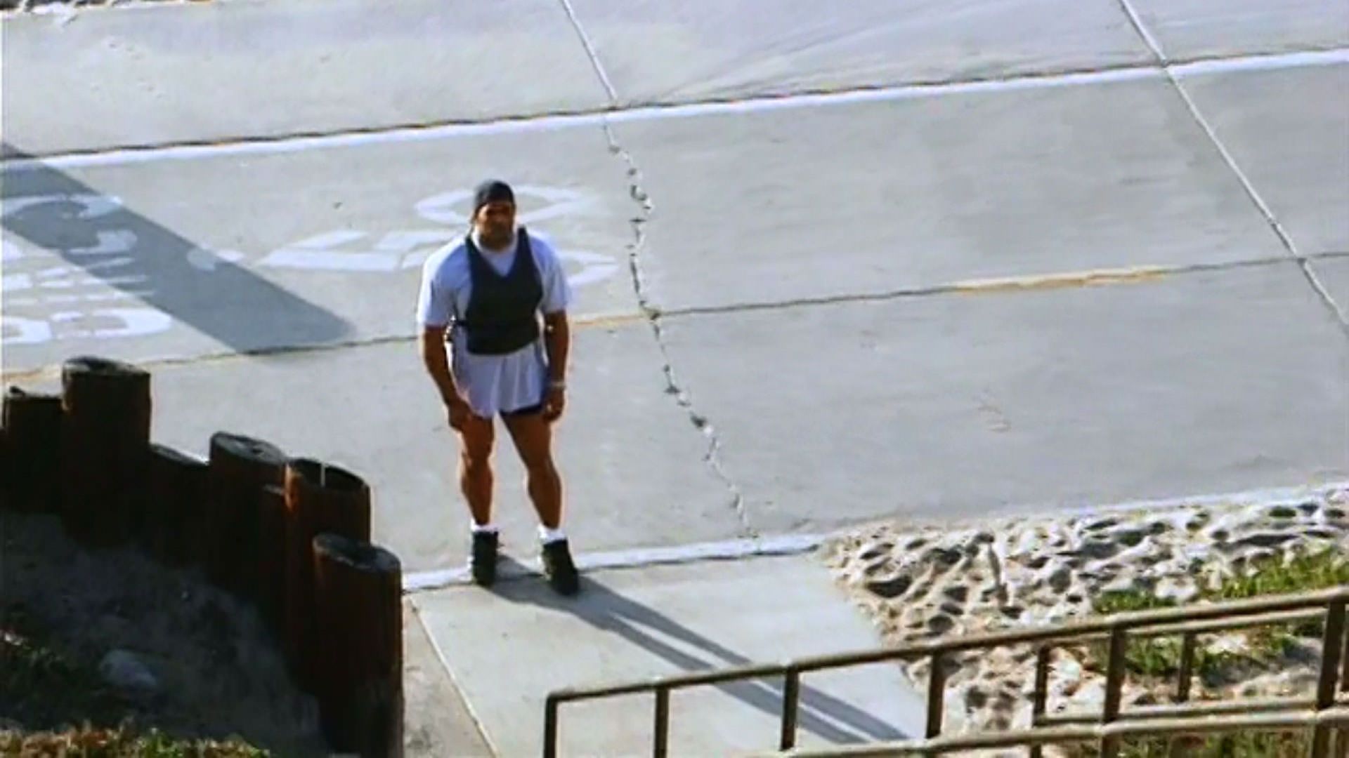 مارک کر پایین پله‌ها ایستاده است در نمایی از مستند ماشین کوبنده به کارکردانی جان هایمز