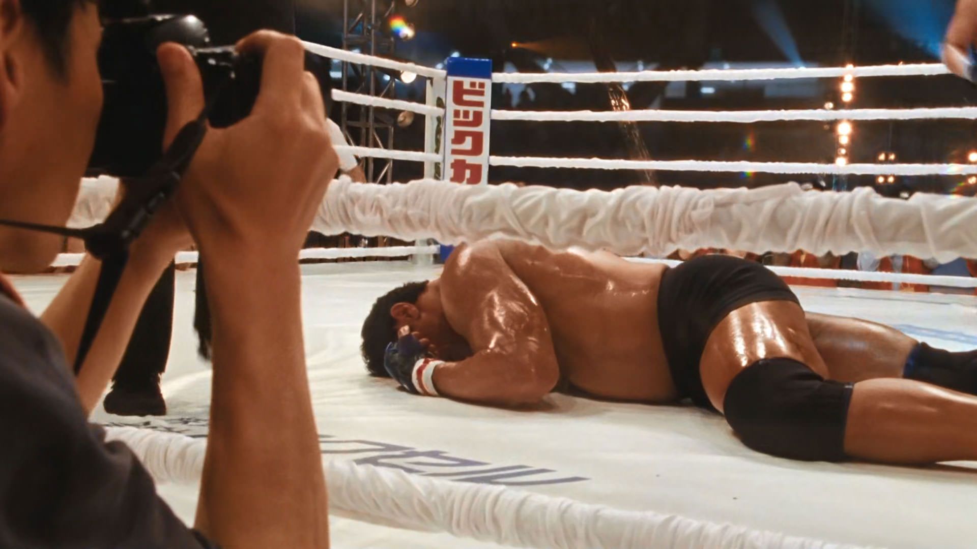 دواین جانسون راک روی زمین افتاده و داخل رینگ ناک اوت شده است در نمایی از فیلم ماشین کوبنده به کارگردانی بنی سفدی