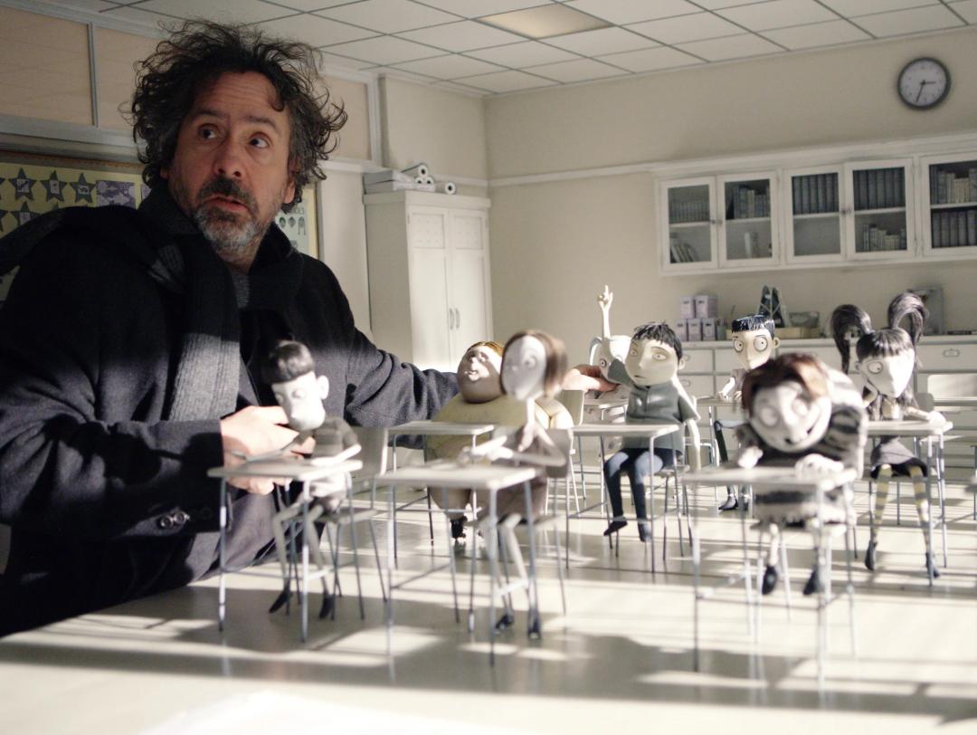 تیم برتون (Tim Burton) در کنار عروسک‌های کوچک گوتیک در یک کلاس درس