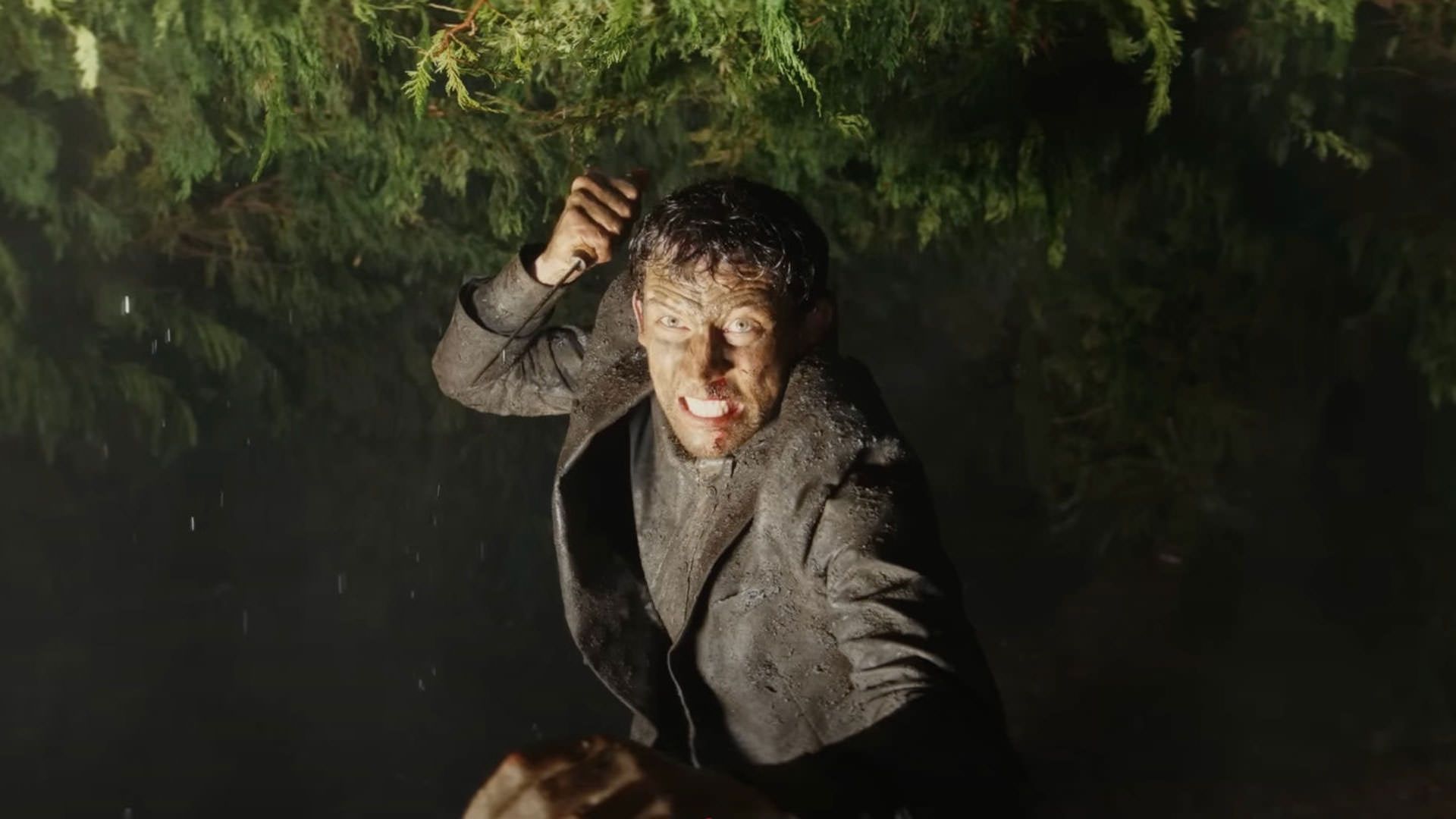 جاش اوکانر با لباس گلی یک کشیش با عصبانیت روی کسی چاقو می‌کشد در حالی که نور به صورت‌اش تابیده است در نمایی از فیلم چاقوکشی: بیدار شو مرد مرده ریان جانسون