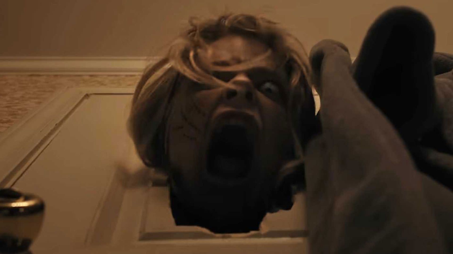 یک زامبی با سرش دری را شکسته است و فریاد می‌زند در نمایی از فیلم سلاح ها به کارگردانی زک کرگر