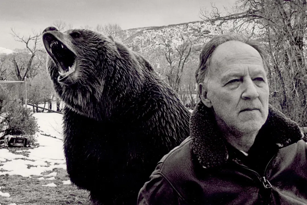 ورنر هرتزوگ (Werner Herzog) در کنار یک خرس در حال غرش در طبیعت برفی