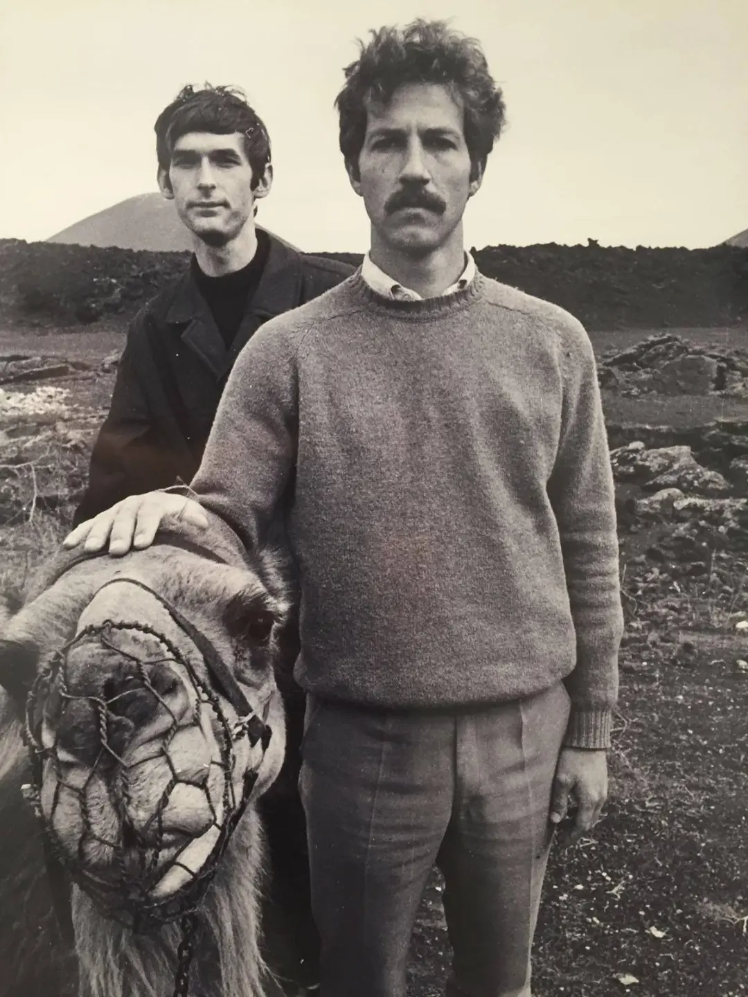 ورنر هرتزوگ (Werner Herzog) در کنار یک شتر در محیطی کوهستانی